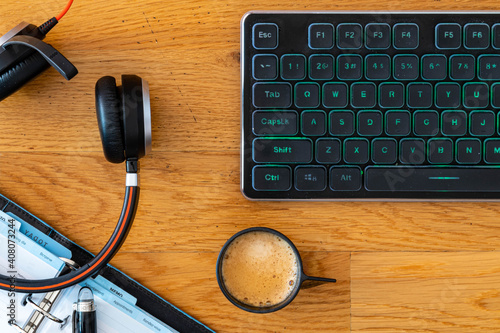 Smart working desktop with laptop, headset, agenda and coffee