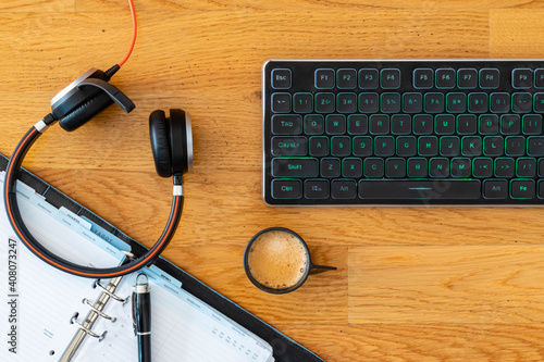 Smart working desktop with laptop, headset, agenda and coffee