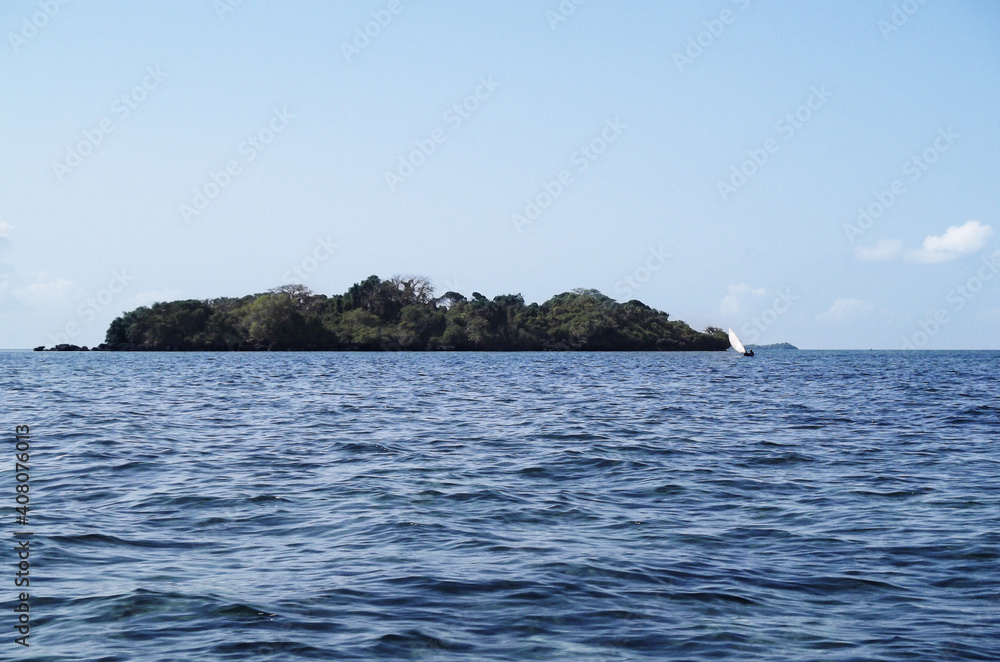 Island in the sea and sailboat