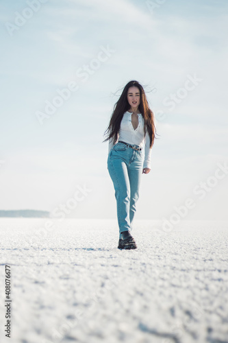 beautiful brunette girl in jeans walks on ice