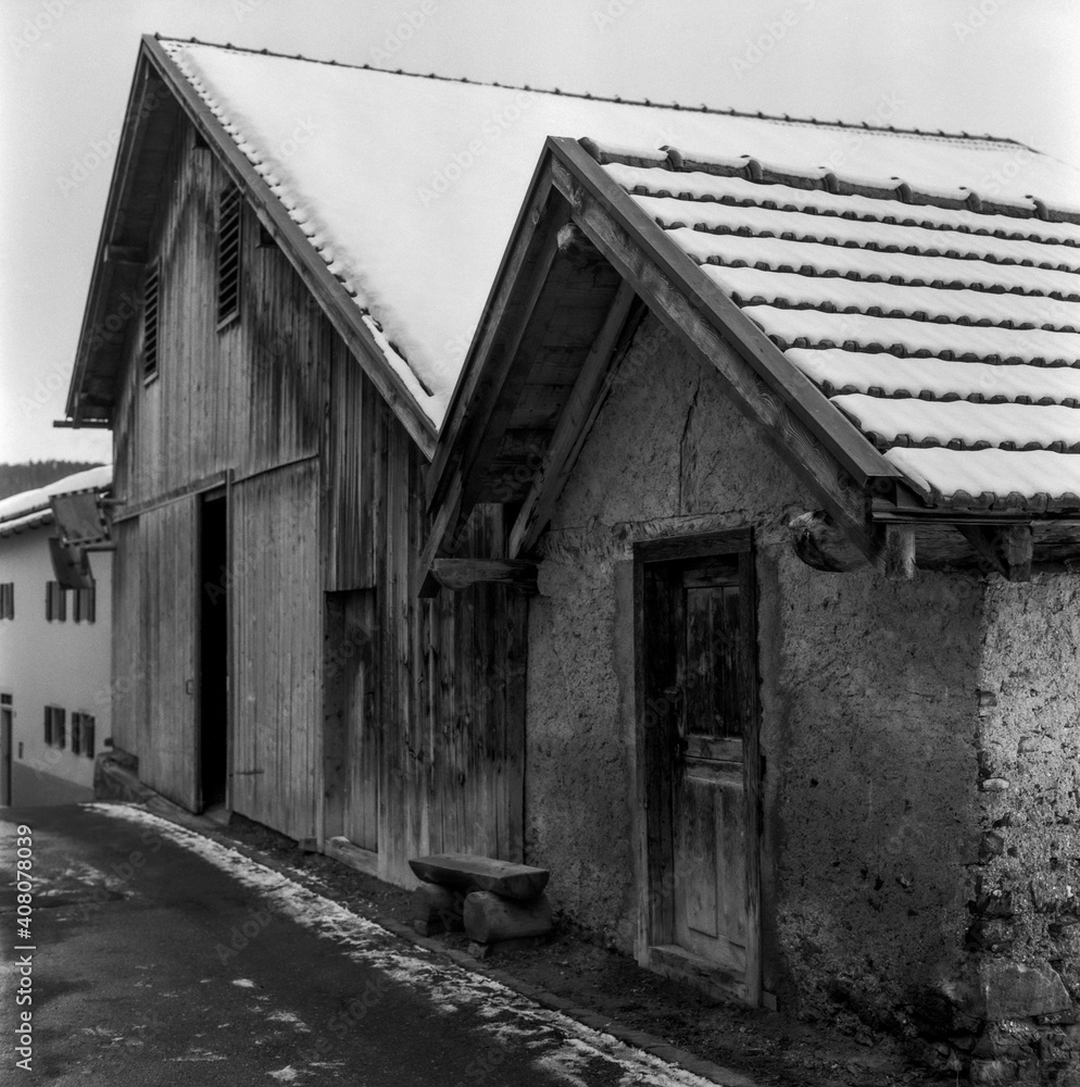 Old log huts for animal shelters in the Swiss village of Alvaneu, shot with analogue photography technique Old log huts for animal shelters in the Swiss village of Alvaneu, shot with analogue photography technique