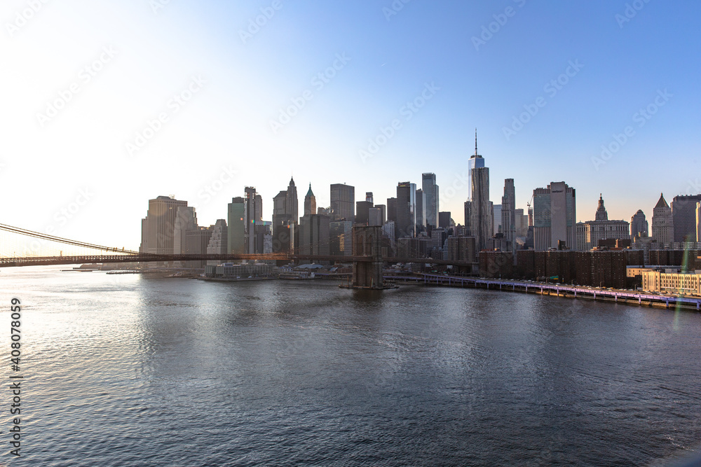 Naklejka premium New York City skyline with skyscrapers at sunset. Downtown Manhattan known as Financial district surrounded by river