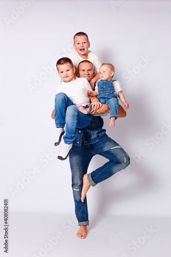 Happy man in denim holds three children