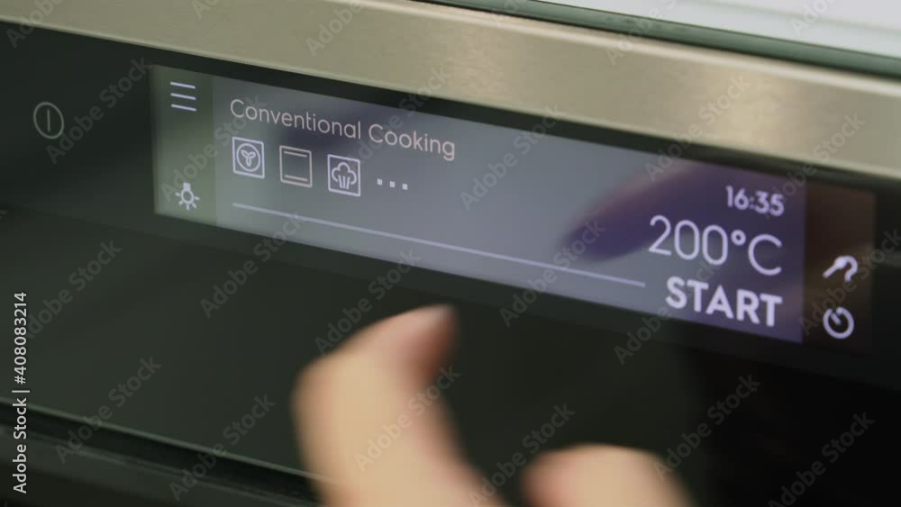 Turning on the oven before cooking. Modern oven with touch panel, close-up. Woman sets the temperature for cooking and turns on the oven. View of finger pushing touch panel on a cooking stove. Turning on the oven before cooking. Modern oven with touch panel, close-up. Woman sets the temperature for cooking and turns on the oven. View of finger pushing touch panel on a cooking stove.