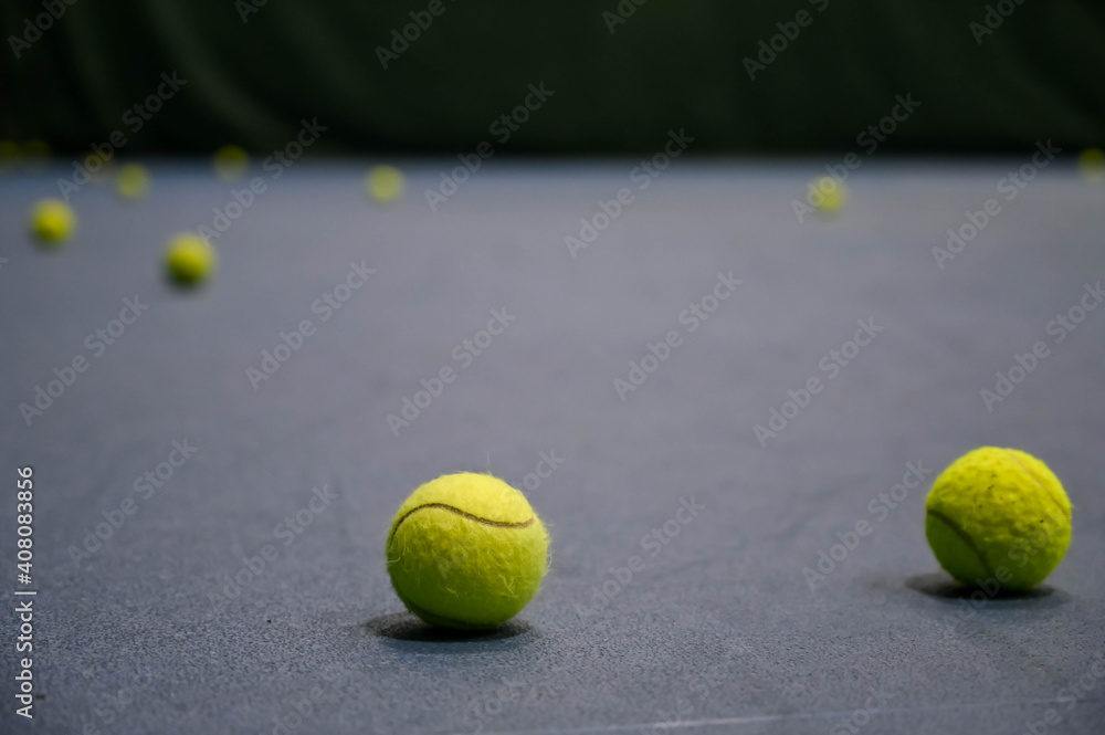 Close-up of tennis balls on blue hard court.