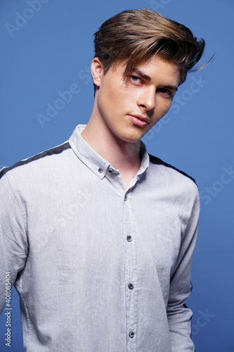 Handsome yong man with stylish haircut on blue.
