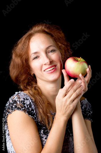 Joyful woman holding fresh apple