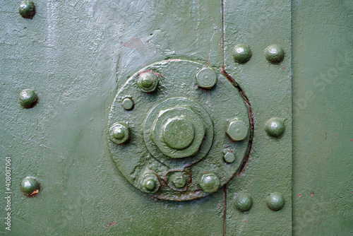 Abstract green metal background with bolts and rivets, copy space. Old painted steel texture, detail of military aircraft. Army, war concept. Top view, flat lay