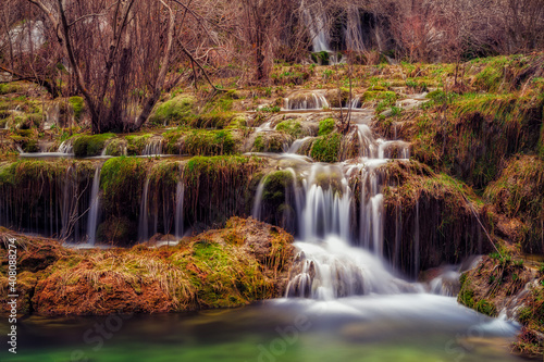 Cascada de agua en nacimiento río Cuervo entre musgo verde © JuanMiguel