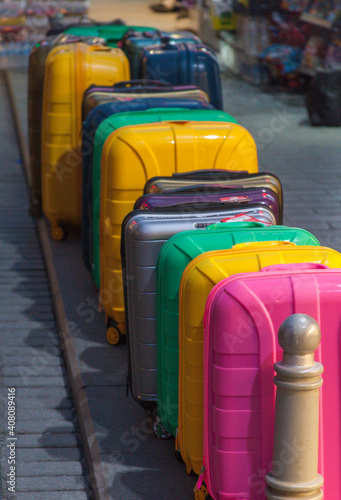 different sized and colored luggage are displayed on the street.