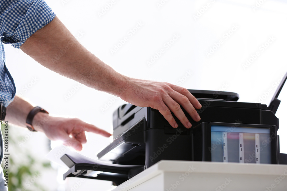 Obraz premium Employee using modern printer in office, closeup