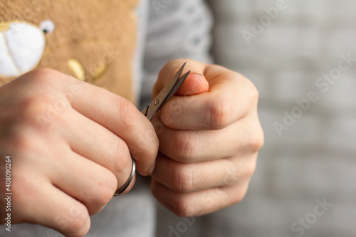 Cut your nails. A young man cuts his nails with nail scissors. Taking care of your appearance and yourself.