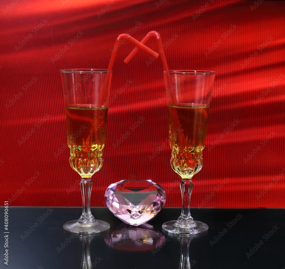
Valentine's day wine glasses filled with drink with straw on red background