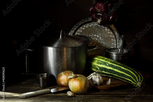 Eggplant near metal dishes on a wooden table.