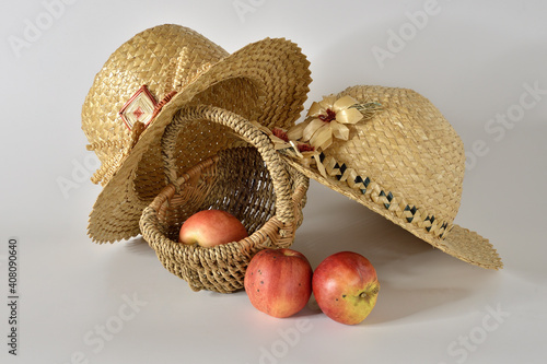 Straw hats, a basket, and three apples.