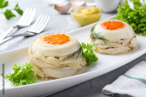 Delicious chicken aspic with eggs and vegetables on plate, closeup