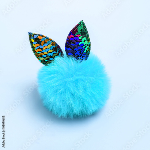 Cute fluffy ball toy with ears on pastel background. Concept of care, holiness, surprises