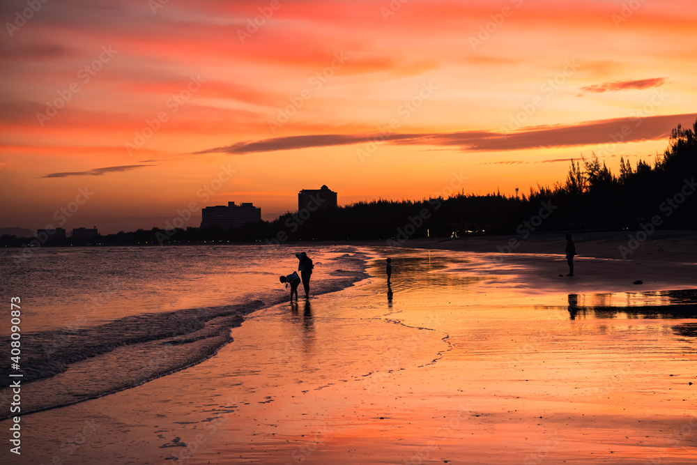 Happy silhouette family enjoy beach at dusk