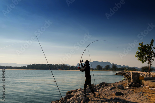 Fisherman using rod fly fishing at tropical sea
