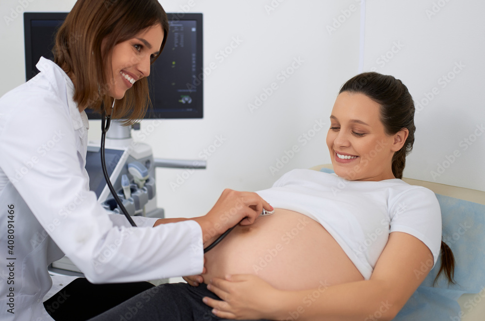 Qualified doctor doing medical check up of pregnant woman Qualified doctor doing medical check up of pregnant woman