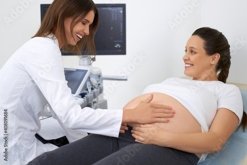 Competent doctor doing palpation of pregnant woman