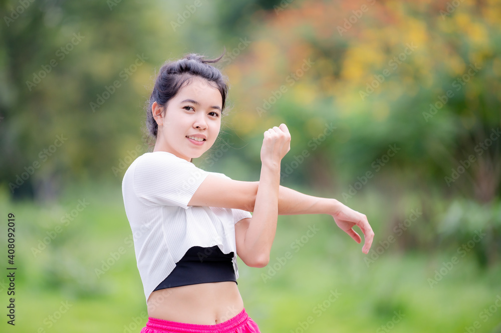A beautiful Asian woman is warm up, To make the muscles flexible Before going to jogging A beautiful Asian woman is warm up, To make the muscles flexible Before going to jogging