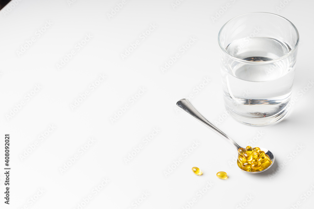 Glass of water and vitamin D on a light background Glass of water and vitamin D on a light background