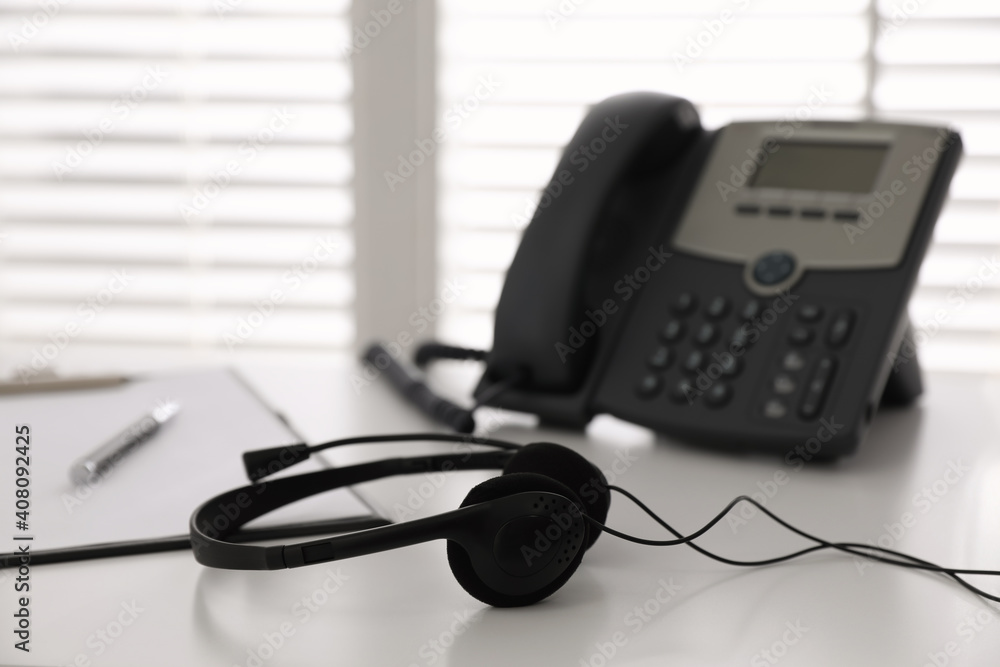 Headset on white table in office, space for text. Hotline service Headset on white table in office, space for text. Hotline service