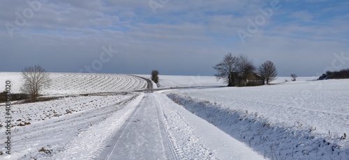 Winter landscape with snowy fields and blue sky