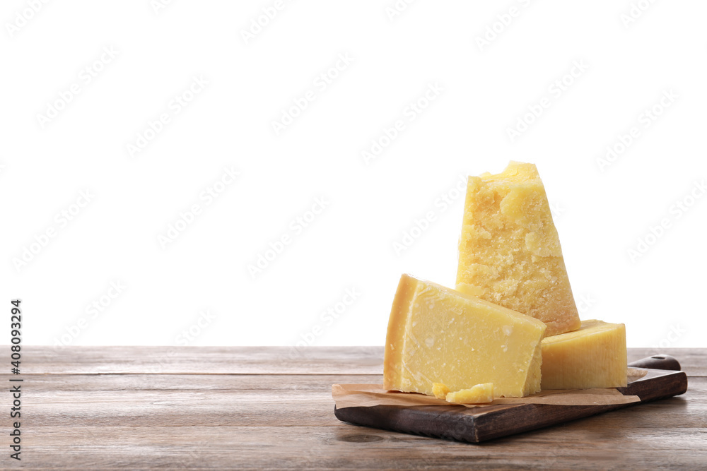 Pieces of delicious parmesan cheese on wooden table against white background. Space for text
