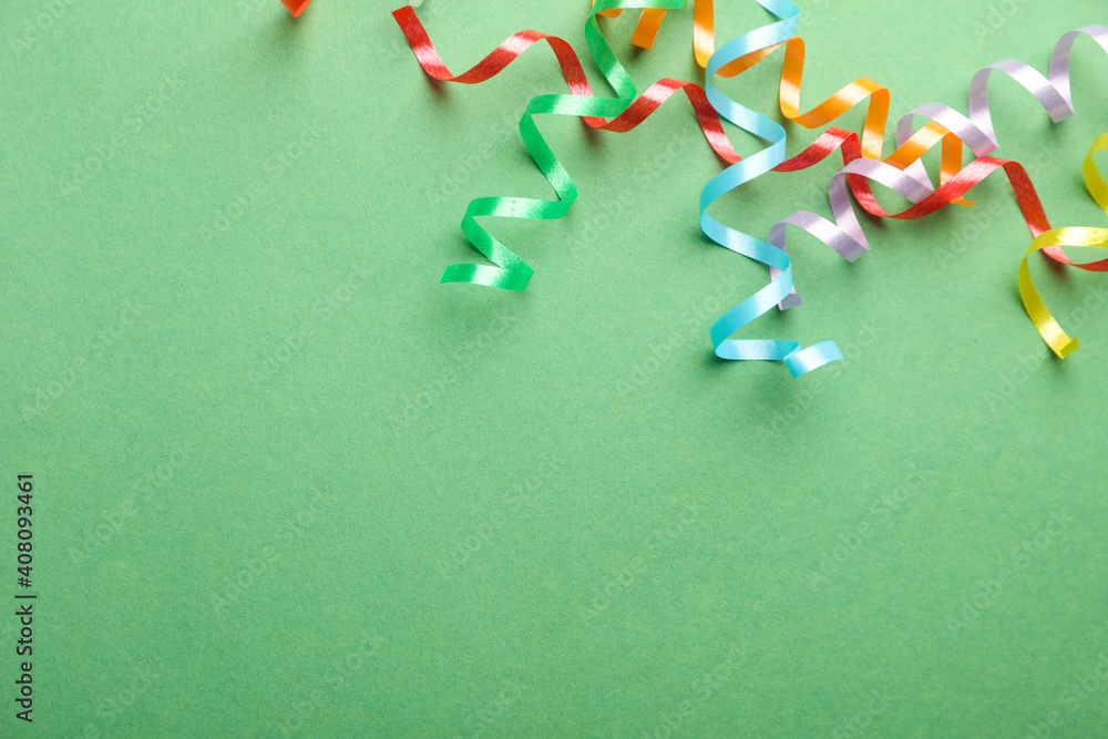 Colorful serpentine streamers on green background, flat lay. Space for text Colorful serpentine streamers on green background, flat lay. Space for text