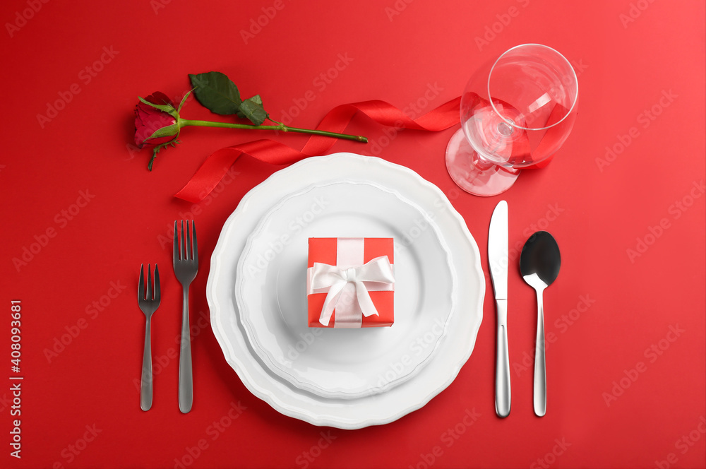 Beautiful table setting for Valentine's Day dinner on red background, flat lay Beautiful table setting for Valentine's Day dinner on red background, flat lay