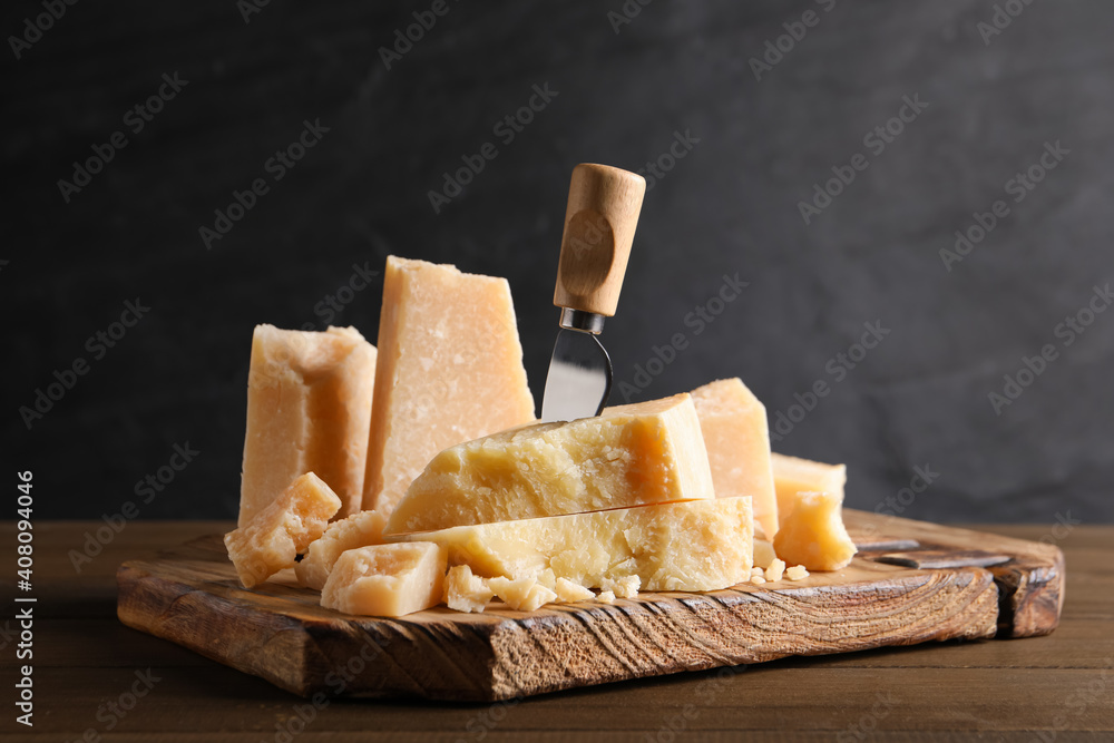 Fototapeta premium Parmesan cheese with board and knife on wooden table