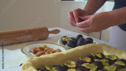 Woman preparing fresh plum pie 