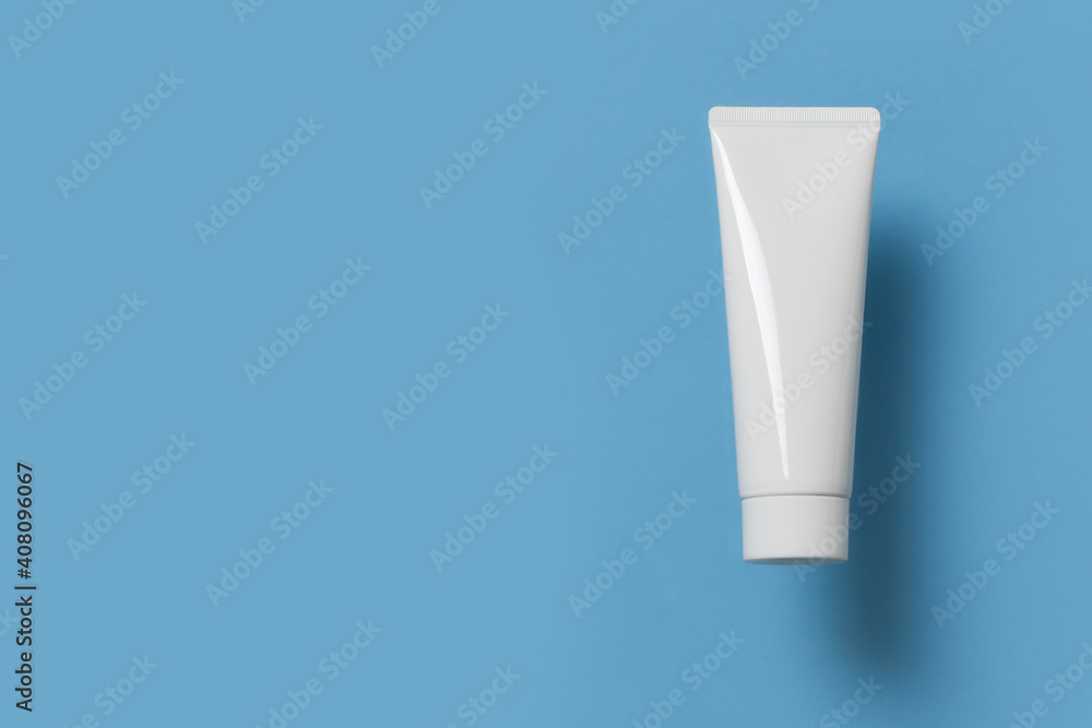 Beauty levitation concept with cream tube, jar and serum on blue background Beauty levitation concept with cream tube, jar and serum on blue background