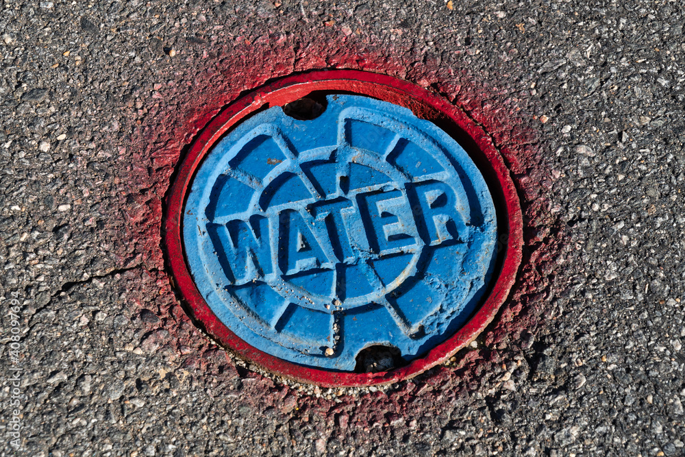 Red and blue water access point in the asphalt Red and blue water access point in the asphalt