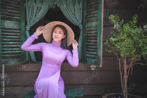 Young Vietnam woman wearing Ao Dai culture traditional at old temple at Ho Chi Minh in Vietnam,vintage style,travel and relaxing concept.