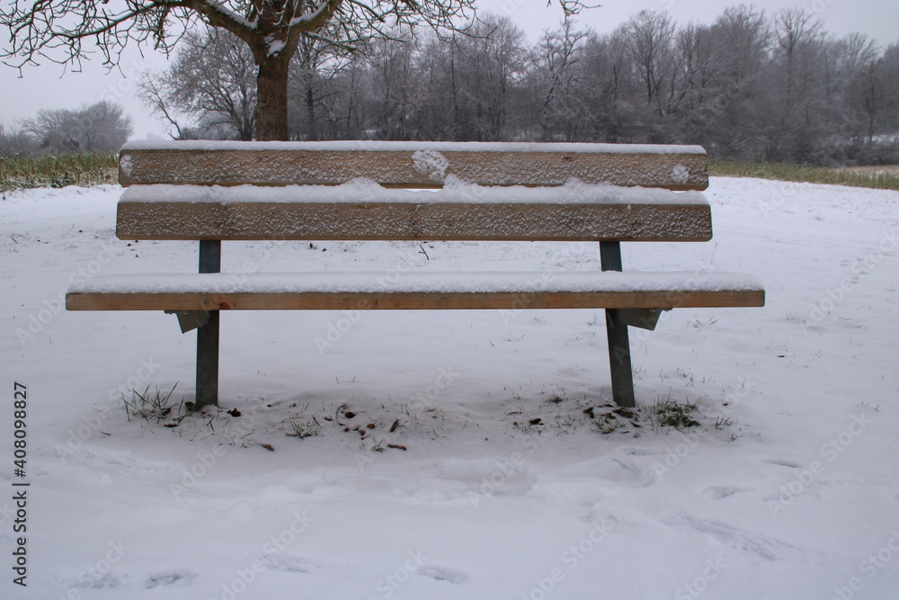 Sitzbank die im Winter mit Schnee bedeckt ist