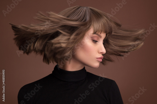 Fotobehang Portrait of a beautiful brown-haired woman with a short haircut on a brown backg