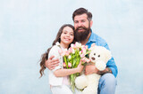 happy family of father and daughter embrace with spring tulip flower bouquet and teddy bear toy, 8 march