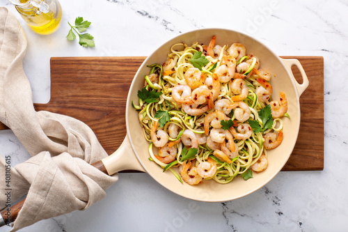 Shrimp and zucchini noodles or zoodles pasta with parmesan and chili flakes cooked in a cast iron pan photo