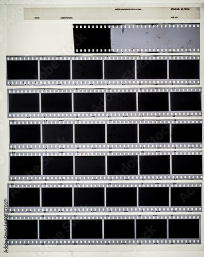 macro photo of blank 35mm filmstrips on white background behind foil.