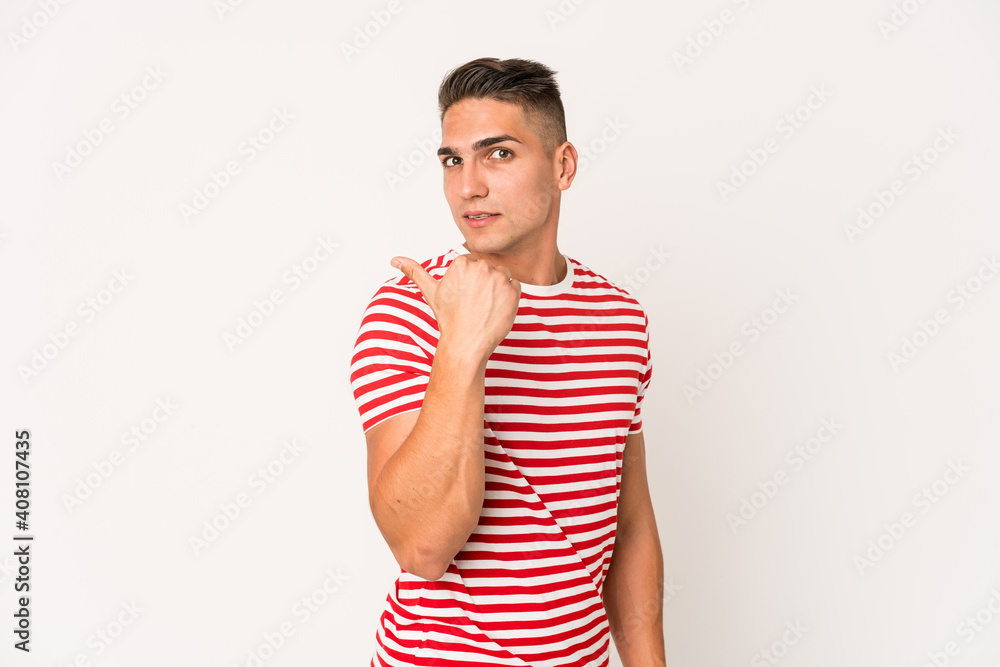 Young caucasian handsome man isolated points with thumb finger away, laughing and carefree. Young caucasian handsome man isolated points with thumb finger away, laughing and carefree.