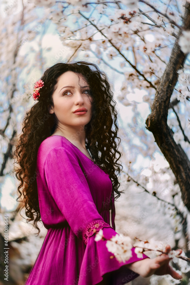 Nice girl with pink dress holding the apricot branch during the blossom Nice girl with pink dress holding the apricot branch during the blossom