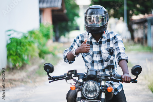 African biker in the helmet and glasses driving a motorcycle rides © arrowsmith2