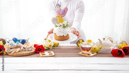 Easter composition with a beautifully decorated festive cake in female hands.