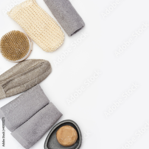 Flat lay composition with bath accessories with Soap, cotton towel, washcloth for bath, wooden comb on white