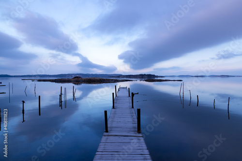 Beautiful seascape with bridge  rocky islands  and magenta clouds in a symmetrical composition on an early morning in Sweden