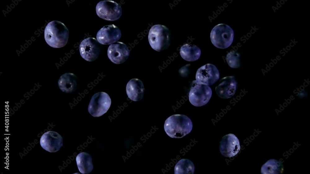 Top view of large blueberries bouncing and rotating on the black background in slow motion Top view of large blueberries bouncing and rotating on the black background in slow motion