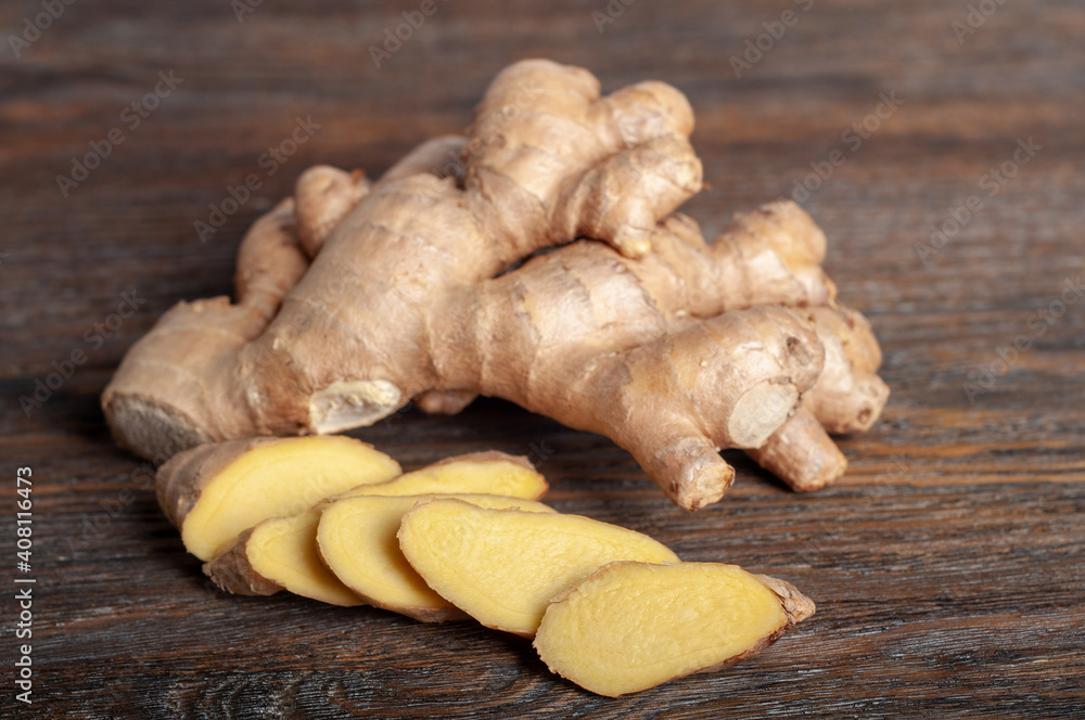Fresh sliced ginger root on a wooden table. Fresh sliced ginger root on a wooden table.